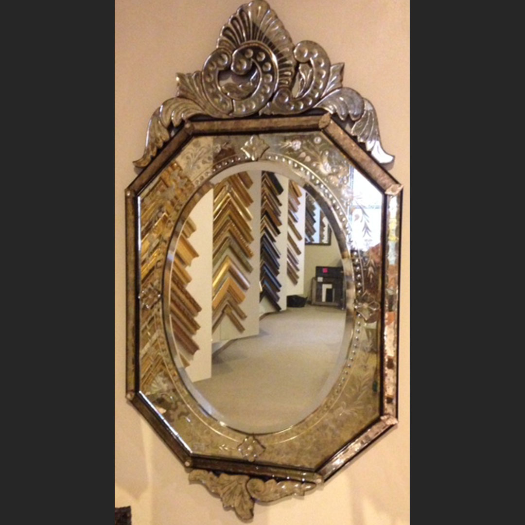 Hand-carved, round mirror designed by Lichten Craig Architecture & Interiors, fabricated entirely at Artmill Group's workrooms. Carved out of basswood, finished in 22k gold over a red bole with a matte black lip. This frame is shown with custom antique mirror.