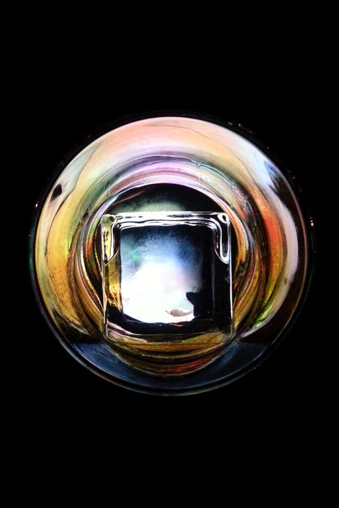 An ice cube at the bottom of a bourbon glass.